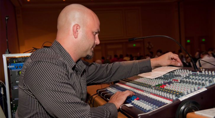 Image: Audio engineer preparing for a speaker at a Benchmarc360 organized event. Event and meeting technology and software soltuions.