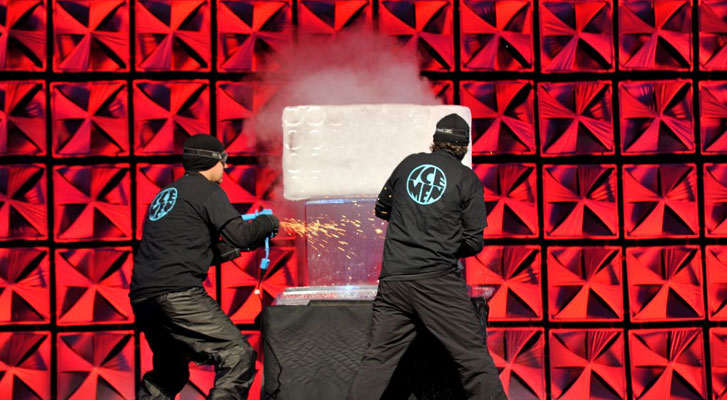 Image: Ice Men perform on stage in front of captivated corporate event audience. Event branding services by Benchmarc360.